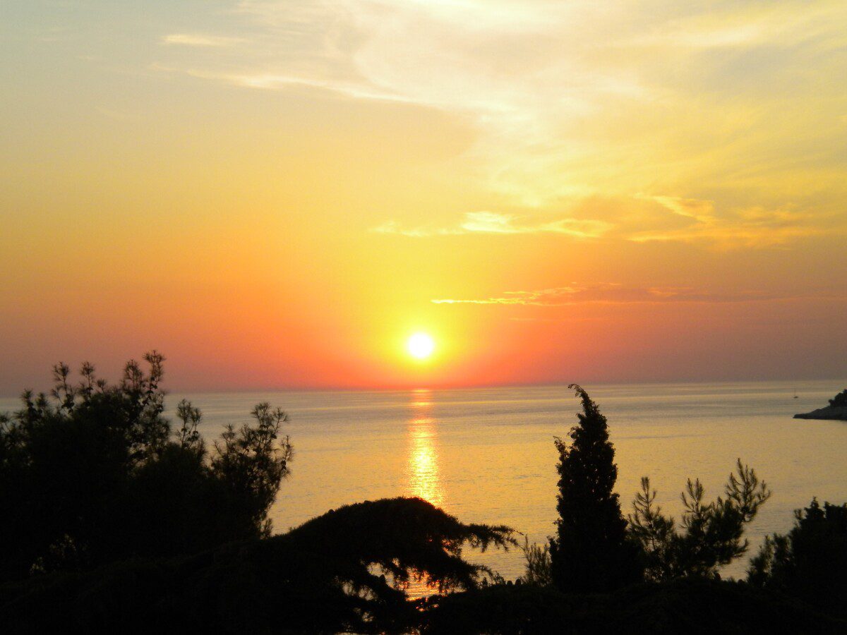 Mani della donna che tengono il sole all'alba